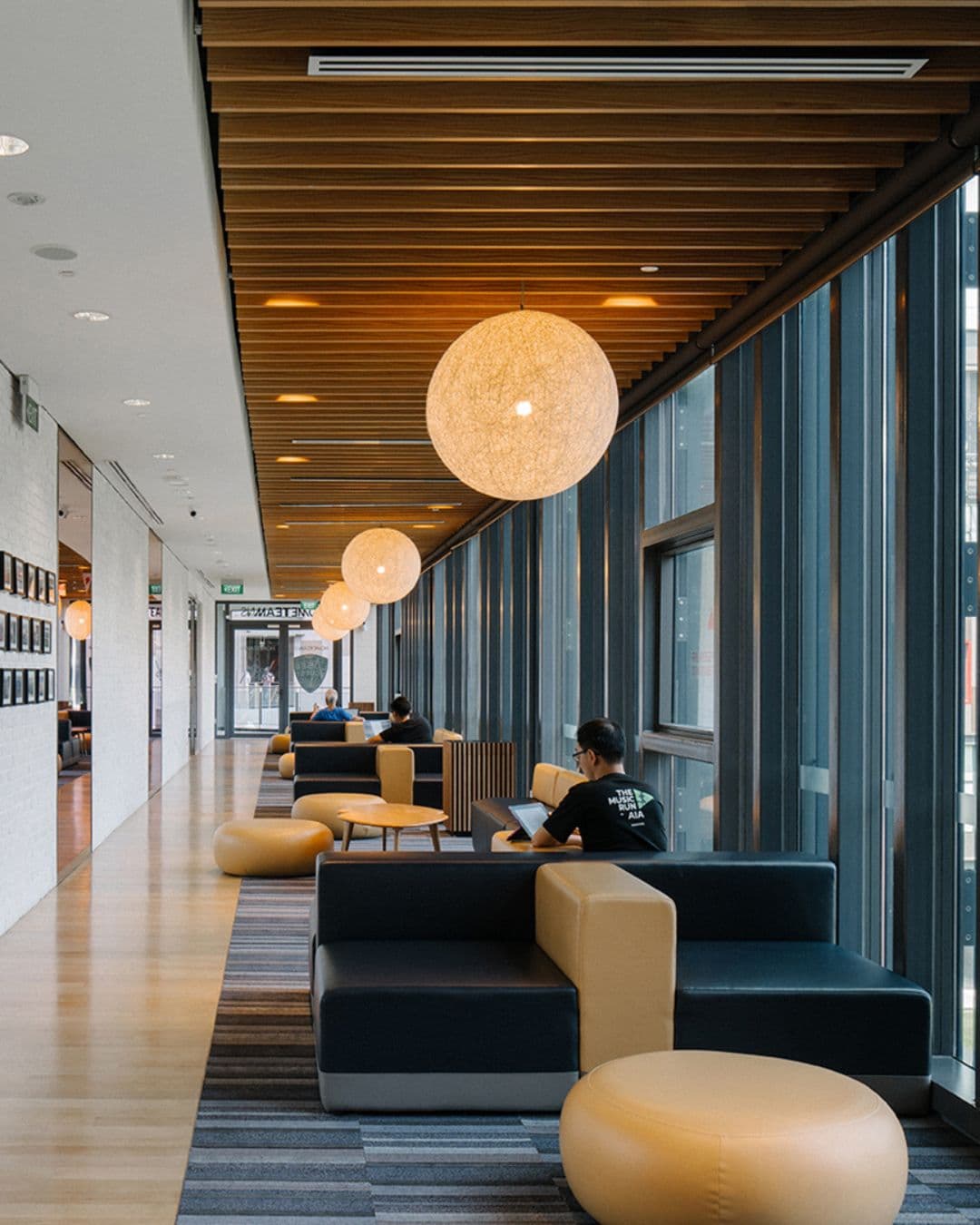 Our Tampines Hub – Modern Corridor Spaces for Quiet Study Sleek corridor at Our Tampines Hub with cozy lighting and glass walls
