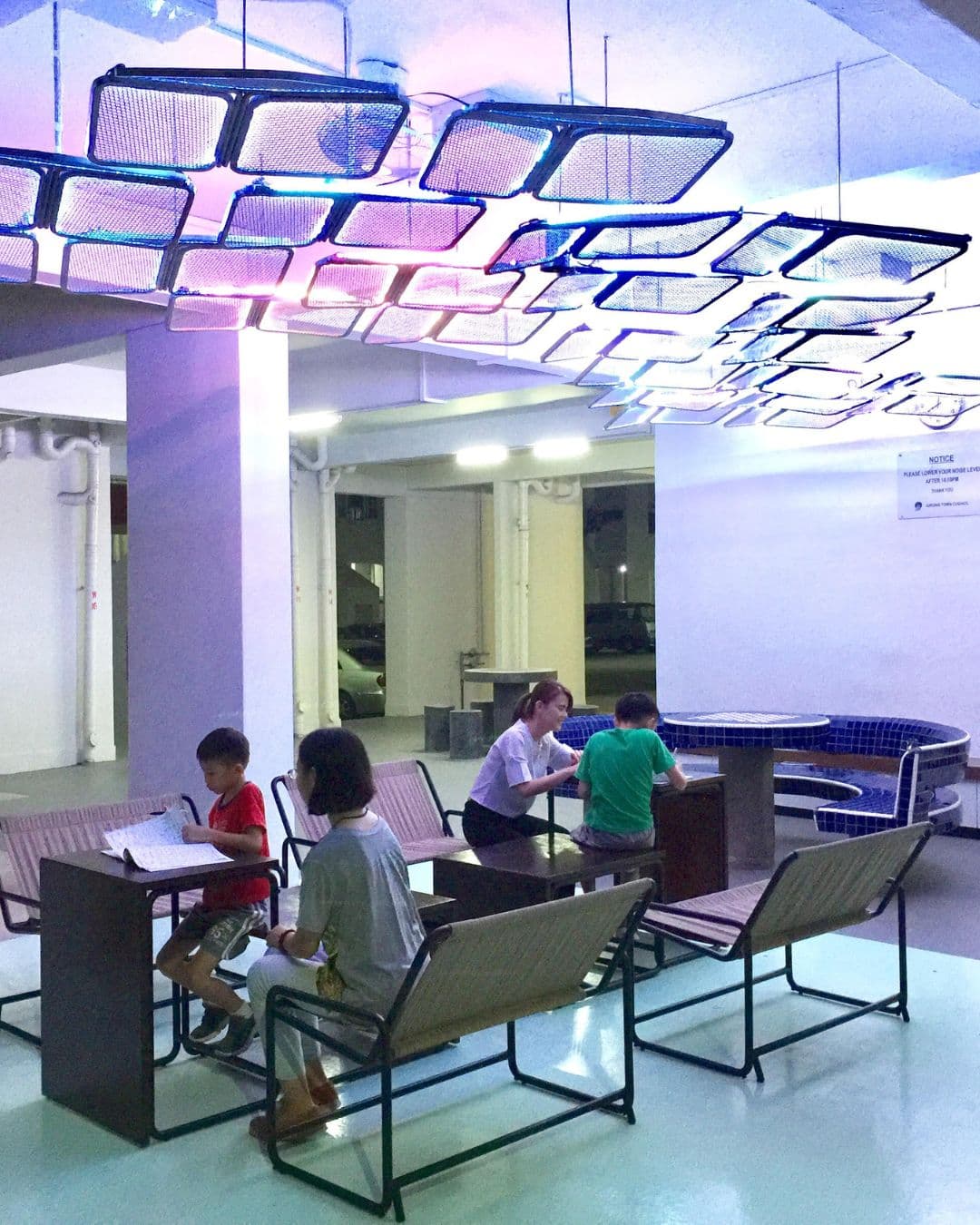 Smart Void Deck – Creative Study Pods for Students Kids studying under modern lighting at Smart Void Deck with foldable furniture