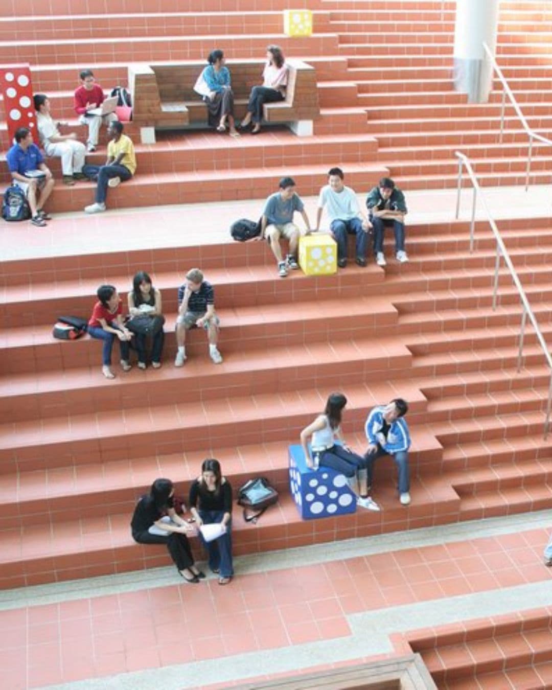 SMU Campus – Creative Outdoor Study Spots for Students Young students studying outdoors on stair-like modern seating at SMU